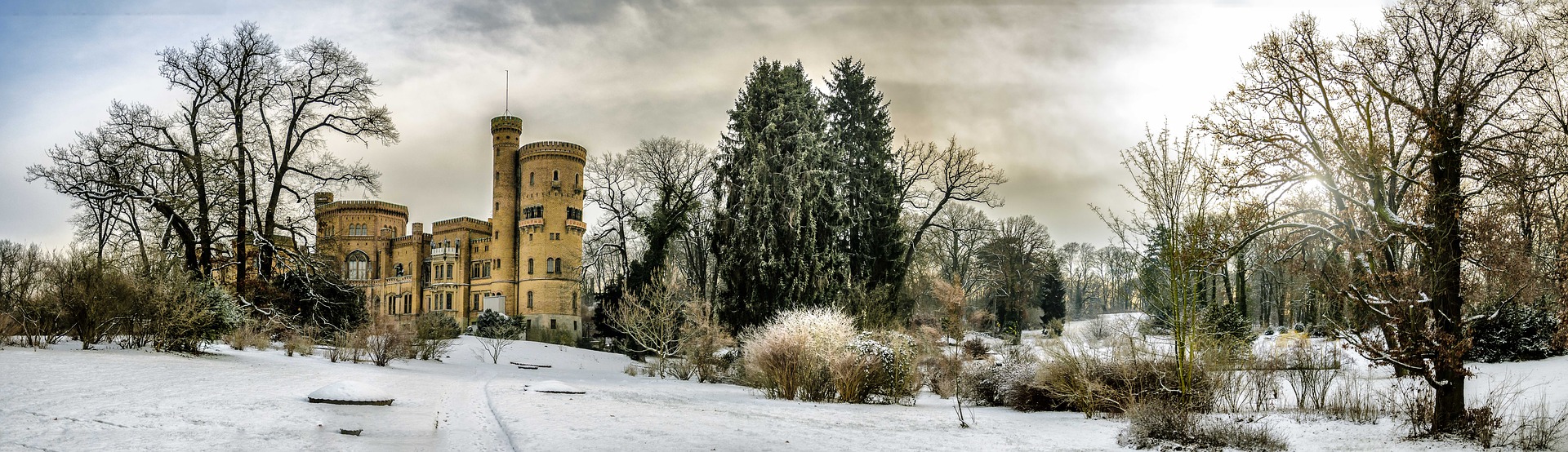 Paesaggio innevato con piante e castello